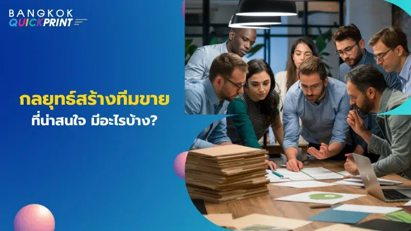 กลุ่มคนกำลังประชุมและพูดคุยถึงแผนงานที่โต๊ะประชุมซึ่งมีเอกสารและตัวอย่างผลิตภัณฑ์วางอยู่