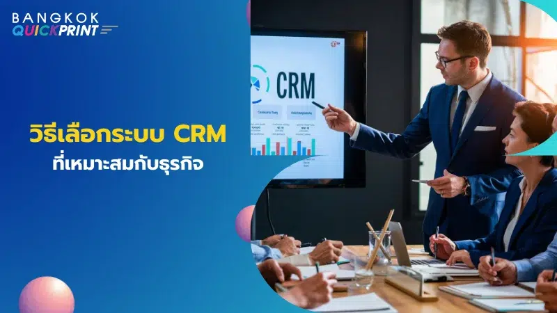 ผู้ชายในชุดสูทกำลังอธิบายระบบ CRM บนหน้าจอคอมพิวเตอร์ให้กับทีมงาน